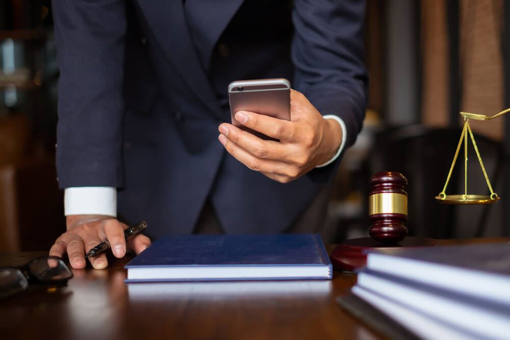 Man At Courtroom Desk Using Cellphone